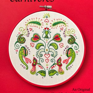 May include: A hand-embroidered pattern on white fabric, stretched within a red embroidery hoop. The design features green and red carnivorous plants, insects, and hearts. Text reads "The Carnivores" and "An Original Hand Embroidery Pattern By Clara Batton Smith."