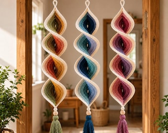 May include: Three hanging spiral decorations made of crocheted yarn. Each piece features a gradient color scheme: one in green and orange, one in blue and teal, and one in pink and purple. Each spiral ends with a wooden bead and a yarn tassel.