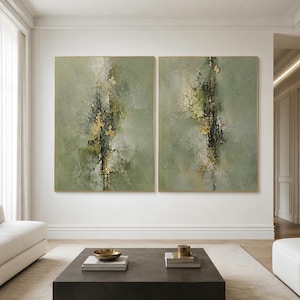 Puede incluir: Dos lienzos rectangulares de arte mural con capas abstractas texturizadas en tonos verde salvia, oliva y gris carbón. Las composiciones están acentuadas con detalles de pan de oro metálico aplicados en trazos verticales y centrales.