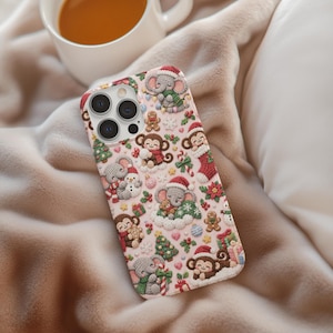 May include: A light pink smartphone case featuring a repeating pattern of crocheted-style Christmas motifs, including elephants in Santa hats, monkeys, gingerbread men, decorated pine trees, candy canes, stockings, and small colourful gift boxes.