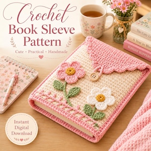 Puede incluir: Una funda de libro de ganchillo rectangular con base color crema, solapa festoneada rosa y cierre de botón de madera. La parte frontal está decorada con dos flores de ganchillo, una rosa y otra blanca, con tallos y hojas verdes.