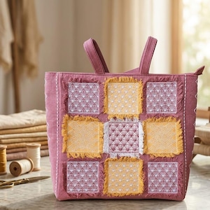 May include: A mauve tote bag featuring a patchwork design of square fabric panels with frayed edges. The panels alternate between yellow and mauve, each embroidered with white geometric fan patterns. The bag has two top handles and a zipper.