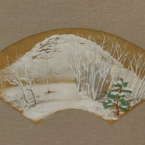 May include: A hand-painted fan depicts a winter landscape. The scene features snow-covered trees and a mountain, with a pheasant in flight. The fan has a brown background and a unique, curved shape.