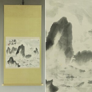 May include: A traditional Asian scroll painting featuring a monochrome landscape with mountains and water. The artwork is mounted on a light yellow background with wooden dowels at the bottom. The painting includes Chinese characters.
