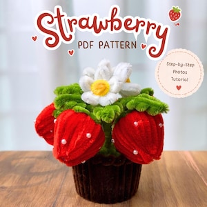 Pode incluir: Um projeto de artesanato com morangos de limpadores de cachimbo vermelhos com sementes de contas brancas, folhas verdes e uma flor branca com centro amarelo, em uma base marrom. Texto: Strawberry PDF PATTERN e Step-by-Step Photos Tutorial.