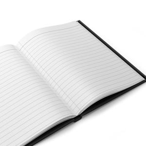 May include: An open notebook with a black cover and white pages featuring thin horizontal black lines. The notebook is positioned at an angle, displaying the interior paper layout with a clear view of the lined pages and the dark binding spine.