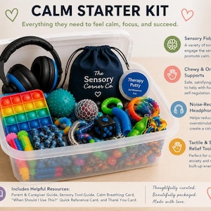 May include: A clear plastic storage bin filled with various sensory items including black noise-reducing headphones, a navy drawstring bag labeled The Sensory Corner Co., a container of therapy putty, a rainbow pop-it, and assorted fidget toys.
