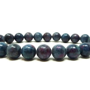 May include: A bracelet made of dark blue and purple gemstone beads. The beads are round and have a smooth, polished finish.