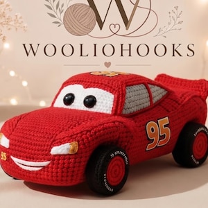Può includere: Un'auto giocattolo all'uncinetto rossa con il numero 95 sui lati e sul cofano, parabrezza bianchi, occhi circolari neri e ruote nere con centri rossi. Un'etichetta mostra il testo CROCHET PATTERN 95 CAR INSTANT DOWNLOAD.