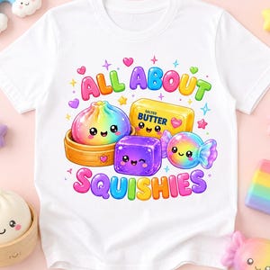 Könnte beinhalten: Ein weißes T-Shirt mit einer bunten Grafik aus einem Regenbogen-Dumpling im Bambusdämpfer, einem gelben Stück gesalzener Butter, einem violetten Würfel und einem Regenbogen-Bonbon. Der Text lautet ALL ABOUT SQUISHIES in bunten Buchstaben.