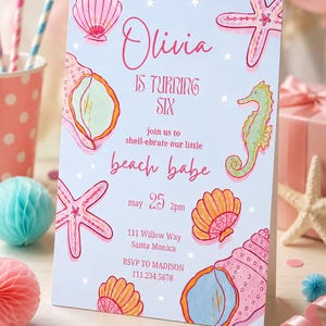 May include: A light blue birthday invitation card featuring pink and orange hand-drawn illustrations of seashells, a starfish, and a seahorse. The text reads: Olivia is turning six, join us to shell-ebrate our little beach babe, may 25 2pm, 111 Willow Way Santa Monica, RSVP to Madison 111.234.5678.
