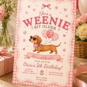 May include: A pink and white gingham birthday invitation featuring a dachshund wearing heart-shaped sunglasses and a polka dot bandana. The text reads: She's a WEENIE BIT OLDER, let's celebrate! Olivia's 5th Birthday, Saturday June 14, 2026, 2:00 PM - 4:00 PM, 123 Hot Dog Lane, Any City, ST 12345, RSVP to Mom 123-456-7890.