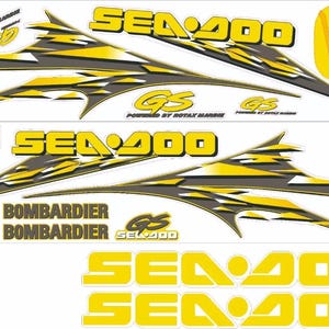 Puede incluir: Un conjunto de calcomanías Sea-Doo GS en amarillo, negro y gris con patrones gráficos angulares y afilados. La hoja incluye varios logotipos de Sea-Doo y GS, el texto Powered by Rotax Marine y Bombardier, y dos grandes marcas Sea-Doo.