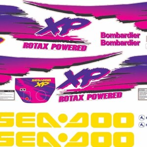 Könnte beinhalten: Ein Set aus Aufklebern mit violetten und pinken Pinselstrich-Grafiken, die den Text XP, ROTAX POWERED, Bombardier und SEA-DOO enthalten. Das Set umfasst gelben SEA-DOO-Schriftzug, kleine Warnhinweise und milmar-Logos auf weißem Grund.