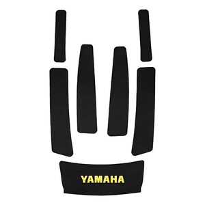 May include: A set of six black adhesive protective pads with a textured surface. Four pads are long and narrow, two are shorter, and one wider bottom pad features the yellow text YAMAHA printed in a bold, sans-serif font centered on the surface.