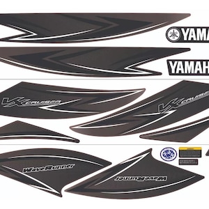 Peut inclure: Un ensemble d'autocollants noirs et gris foncé pour un Yamaha WaveRunner VX Cruiser. La collection comprend de longues bandes graphiques angulaires, deux logos Yamaha, des autocollants VX Cruiser et WaveRunner, et trois petites étiquettes.