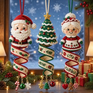 May include: Three hanging crochet ornaments featuring Santa Claus, a decorated Christmas tree, and Mrs. Claus. Each figure is attached to a long, spiralling, embroidered fabric ribbon adorned with festive charms like candy canes and bells.