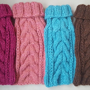 Puede incluir: Cuatro jerséis de punto para perros en diferentes colores: rosa, burdeos, azul y marrón. Cada jersey tiene un patrón de punto de cable y un cuello de tortuga.