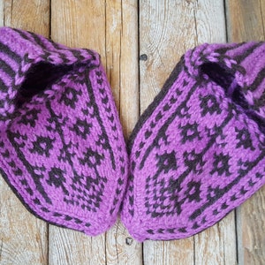 Puede incluir: Un par de zapatillas tejidas a mano con un patr&oacute;n geom&eacute;trico en morado vibrante y marr&oacute;n oscuro. Las zapatillas tienen una construcci&oacute;n de hilo grueso y texturizado con punta puntiaguda y una abertura de pu&ntilde;o acanalado con dise&ntilde;o detallado.