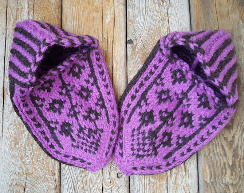 Puede incluir: Un par de zapatillas tejidas a mano con un patr&oacute;n geom&eacute;trico en morado vibrante y marr&oacute;n oscuro. Las zapatillas tienen una construcci&oacute;n de hilo grueso y texturizado con punta puntiaguda y una abertura de pu&ntilde;o acanalado con dise&ntilde;o detallado.