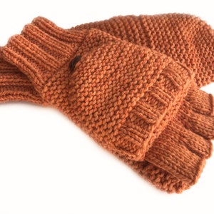 May include: A pair of brown knitted fingerless gloves with a fold-over cuff. The gloves have a small pocket on the back of the hand.