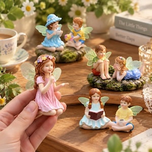 May include: A collection of miniature fairy figurines with translucent wings, including a girl in a pink dress with a flower crown, a girl in a blue dress, a boy in a yellow shirt, and a girl reading a book, all crafted with detailed facial features.