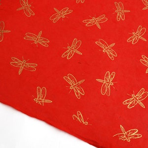 May include: Red wrapping paper with a repeating pattern of gold dragonflies.