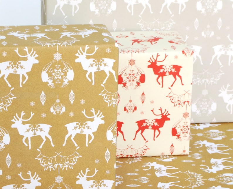 May include: Three rolls of wrapping paper with a reindeer pattern. The top roll is brown with white reindeer, the middle roll is white with red reindeer, and the bottom roll is brown with white reindeer.