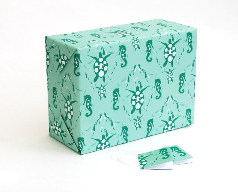 May include: A turquoise gift wrap with a repeating pattern of sea turtles and seahorses. The pattern is in a darker shade of green.