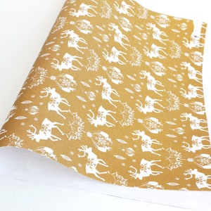 May include: Brown wrapping paper with a white reindeer pattern. The reindeer are silhouetted and have a snowflake design on their antlers.