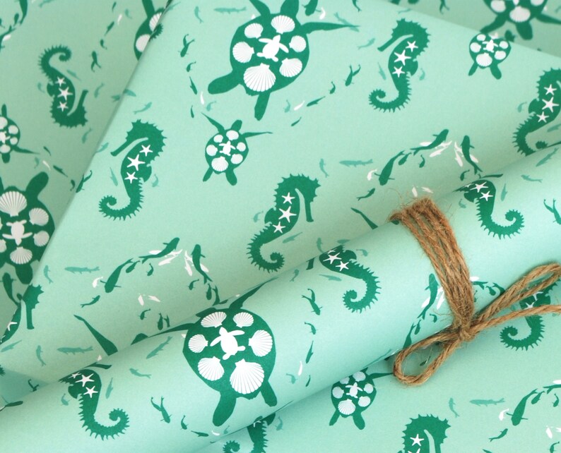 May include: Teal blue wrapping paper with a repeating pattern of seahorses and sea turtles. The seahorses are green and have white stars on them. The sea turtles are green and have white shells.