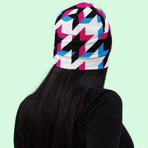 Houndstooth long sleeve crop top. Large houndsteeth. Black and white with offset pink and blue highlights. Back view. Model wears black long sleeve top.