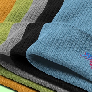 Classic organic cotton ribbed beanie. Synthwave in retro front in bright blue with hot pink shadow over a sunset in hot pink.
6 colours available.
Oxford Navy
Black
Light Avio Blue
Light Grey
Leaf Green
Mustard Yellow.
All base colors shown.