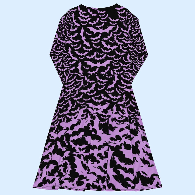 Bats dress. Long sleeves. Midi length (below the knee). Flared skirt. Pockets. Black base with bats of varying sizes in pastel purple (lilac) forming an all over pattern. The skirt has larger bats overlapping each other. Back flat.