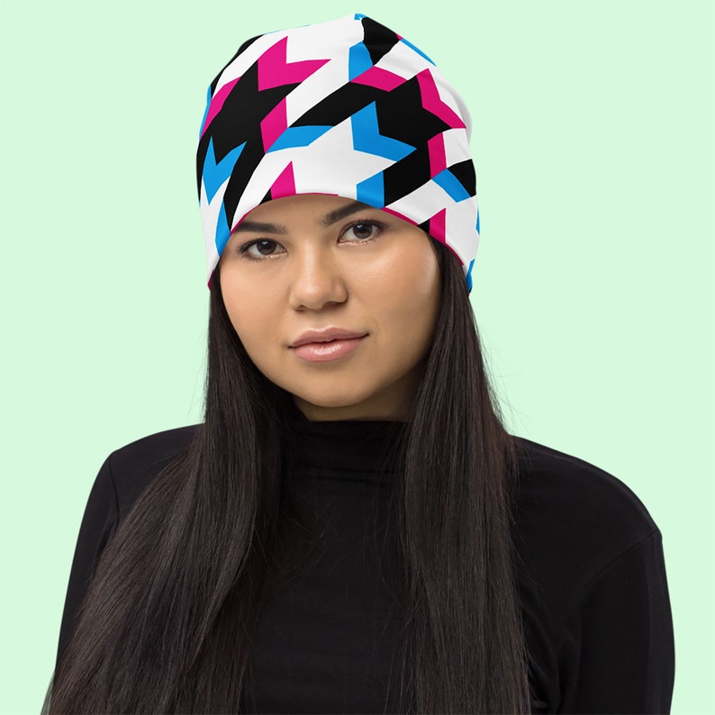 Houndstooth long sleeve crop top. Large houndsteeth. Black and white with offset pink and blue highlights. Front view. Model wears black long sleeve top.