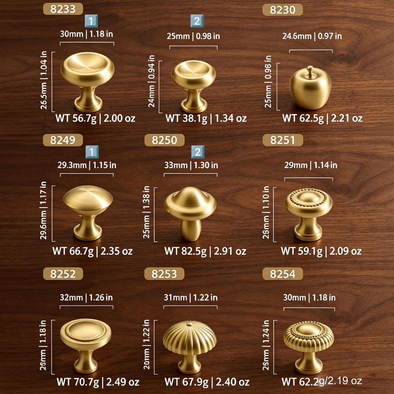 May include: A collection of nine gold-toned metal cabinet knobs in various shapes, including round, apple-shaped, and ribbed designs. Each knob is labeled with a model number, dimensions in inches, and weight in ounces, ranging from 0.98 to 1.38 inches.