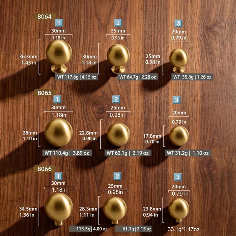 May include: A collection of nine spherical brass cabinet knobs arranged in three rows labeled 8064, 8065, and 8066. Each knob includes printed text indicating its diameter, height, and weight in both metric and imperial units, ranging from 0.79 to 1.18 inches.