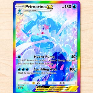 Puede incluir: Una carta coleccionable Primarina ex con un borde holográfico de arcoíris. La carta presenta una ilustración de una criatura acuática azul y blanca, 180 HP, y ataques llamados Hydro Pump y Sparkling Aria. El texto incluye stage 2 y reglas.
