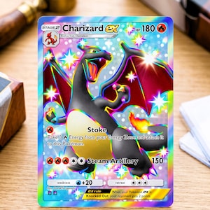 May include: A holographic Charizard ex trading card featuring a black dragon-like creature with red wings and a flame tail. The card displays the text Charizard ex, HP 180, Stoke, and Steam Artillery, set against a rainbow-colored, sparkling background.