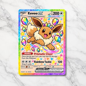 Puede incluir: Una carta coleccionable Eevee ex que muestra un Eevee marrón con una corona de cristal, rodeado de cristales y estrellas flotantes de colores. La carta muestra 200 HP, la habilidad Prismatic Cheer y el ataque Rainbow Tackle de 120 de daño.