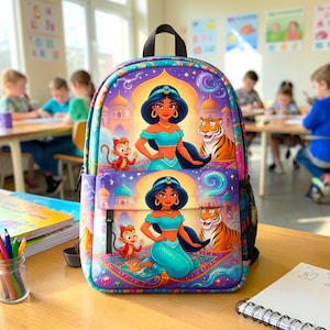 May include: A colorful backpack featuring a graphic print of Princess Jasmine, a monkey, and a tiger against a palace background. The design is repeated on the main compartment and the front pocket, with purple, blue, and gold tones throughout.