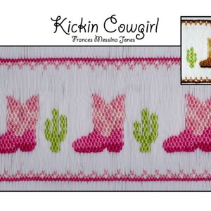 May include: White fabric with pink and green embroidered cowboy boots and cacti. The text "Kickin Cowgirl Frances Messina Jones" is above the design.