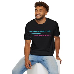 May include: A black short-sleeved t-shirt featuring cyan and pink computer code text that reads: while (treasury.is_printing == true) { currency.debase(); revert("Hyperinflation"); } printed across the centre of the chest area.