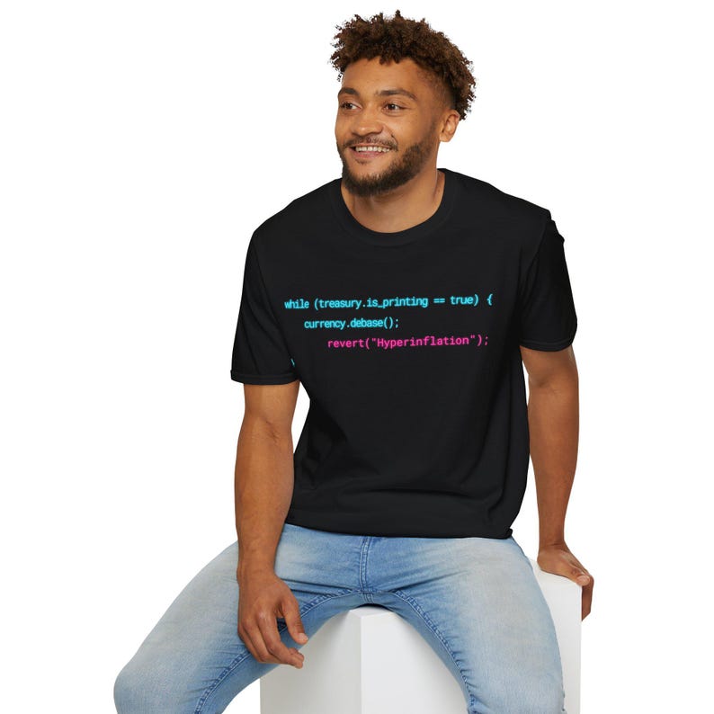 May include: A black short-sleeved t-shirt featuring cyan and pink computer code text that reads: while (treasury.is_printing == true) { currency.debase(); revert("Hyperinflation"); } printed across the centre of the chest area.