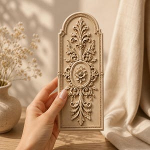 May include: A rectangular, beige-colored decorative wall panel with an arched top, featuring intricate, raised relief carvings of symmetrical acanthus leaves, scrolling vines, and a central floral medallion motif in a classic, ornate style.