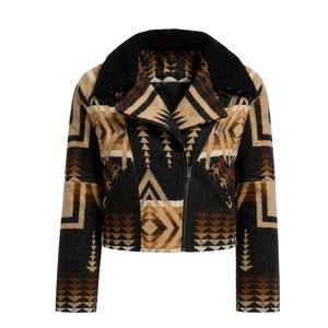 May include: A cropped jacket featuring a black, tan, and brown geometric pattern with a black faux-fur collar. The garment includes a diagonal front zipper closure, long sleeves, and two zippered pockets on the front, showcasing a textured fabric.
