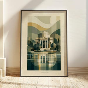 May include: A framed art print featuring a geometric illustration of the Tempio Voltiano in Como, Italy. The composition uses shades of green, beige, and brown to depict the domed building, surrounding trees, and its reflection in the water.