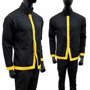 May include: A black long-sleeved jacket with a high collar and a vertical yellow stripe running down the center front. The jacket features yellow trim along the bottom hem and sleeve cuffs, paired with matching black trousers on a mannequin.