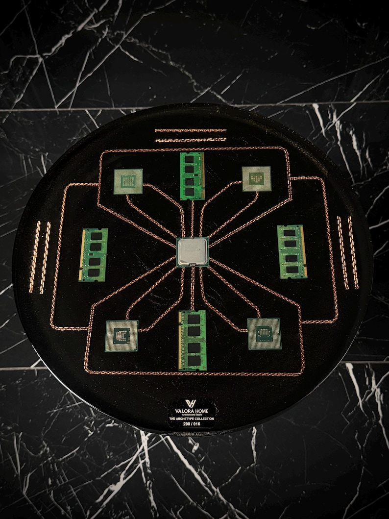 May include: A circular black display piece featuring a central silver processor chip connected by copper wires to four green RAM sticks and four square processor chips. The base includes the text VALORA HOME THE ARCHETYPE COLLECTION 200/016.