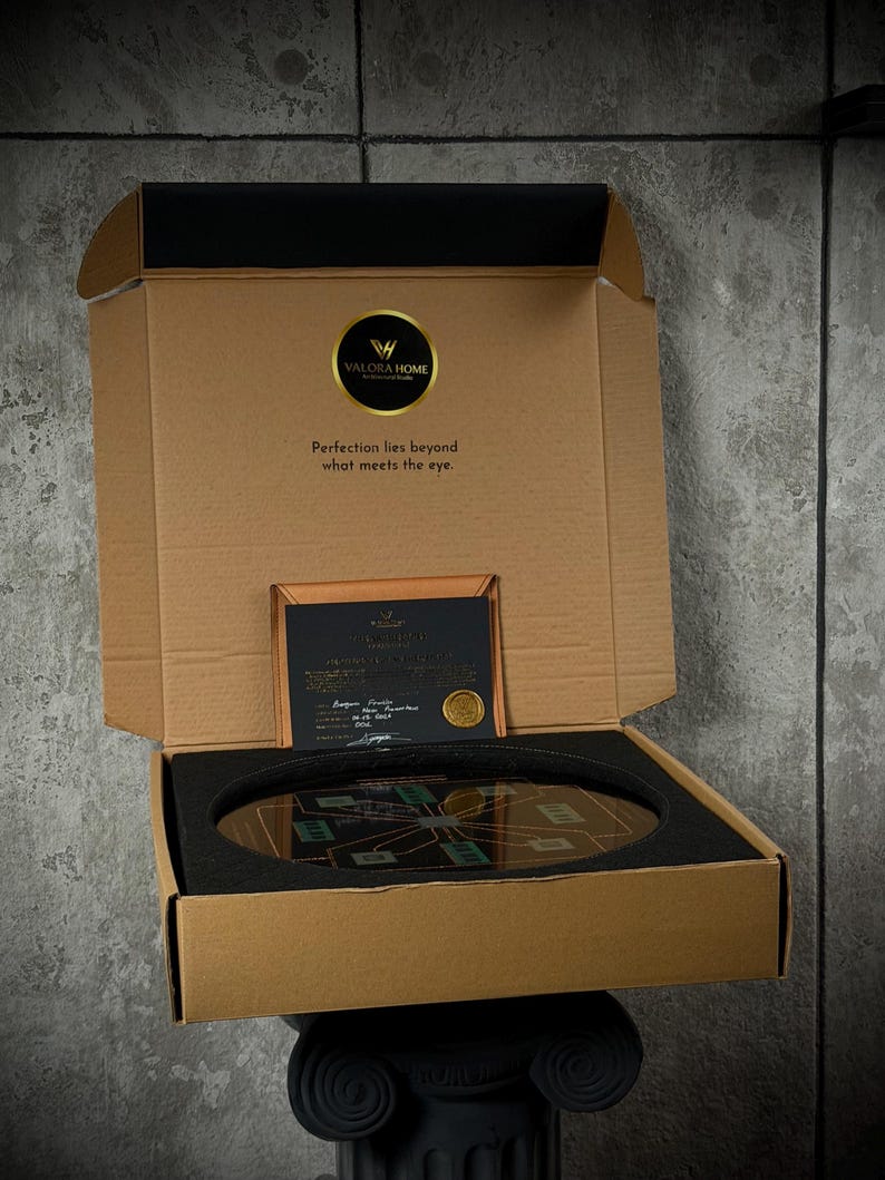 May include: A brown cardboard box with an open lid containing a circular object with a circuit board design, protected by black foam inserts. The lid features the Valora Home logo and the text, Perfection lies beyond what meets the eye.